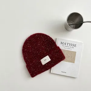 Detalle de gorro de punto rojo, cálido gorro de invierno de mezcla de lana suave con etiqueta.