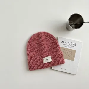 Primer plano del gorro de punto rosa acogedor con textura fina y etiqueta pequeña tejida.