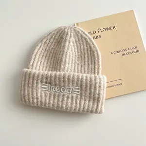 Dettaglio berretto in maglia beige, caldo cappello invernale con ricamo carino.