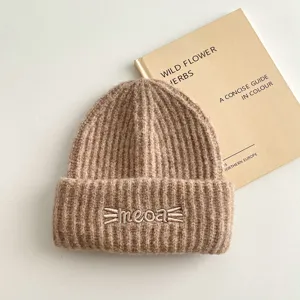 Primo piano dettagliato del simpatico berretto lavorato a maglia con ricamo meoa.