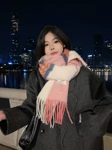 Detailed view of colorful colorblock tassel scarf in night outdoor setting, cozy knit texture.