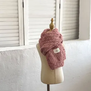 Detalle de bufanda de punto de lana rosa para niños acogedora, perfecta para invierno.