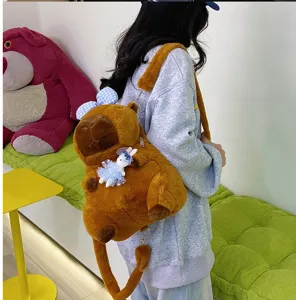 Niña que lleva una linda mochila de peluche de carpincho con un amuleto de conejo