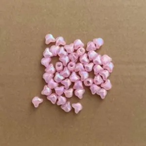 Macro detail of iridescent pink heart-shaped CCB beads for DIY jewelry making crafts.