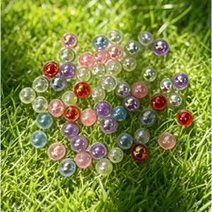 Colorful pearlescent round beads for DIY jewelry making on green grass detail