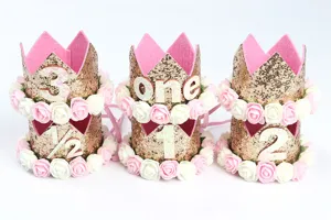 Detalle de coronas de cumpleaños infantiles de purpurina dorada con rosas decorativas.
