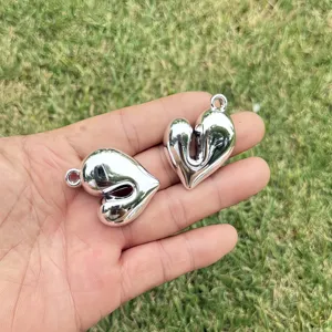 Close-up of shiny silver heart-shaped CCB pendants for DIY jewelry making.