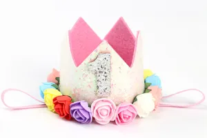 Detalle de una corona rosa brillante para el primer cumpleaños con rosas artificiales