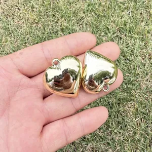 Macro detail view of two shiny gold plated heart shaped pendants for DIY jewelry crafts