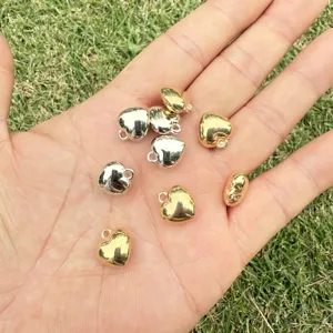 Close-up of gold and silver heart-shaped CCB beads on a palm for DIY jewelry crafts