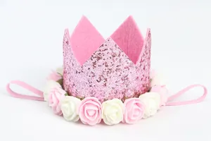 Primer plano de una diadema con corona de purpurina rosa decorada con rosas de espuma.