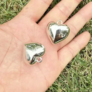 Detailed view of two shiny heart-shaped CCB pendants for DIY jewelry making.