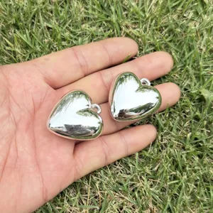 Detailed macro view of two glossy silver-plated heart charms for DIY jewelry making