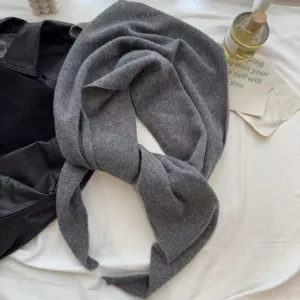 Detail view of the soft gray wool triangular scarf, showing fine knit texture and elegant drape.