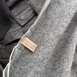 Close-up detail of grey pure wool triangular scarf and shawl texture, cozy winter accessory.
