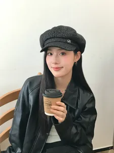 Vue détaillée de la casquette béret léopard sombre avec badge métallique en look quotidien.