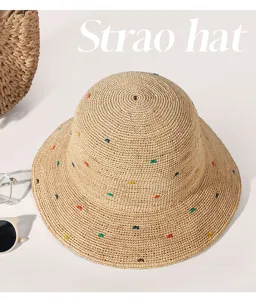 Detailansicht des handgeflochtenen Strohhutes mit bunten Punkten für Strand und Sommer.