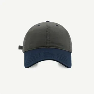 Gorra de béisbol bicolor suave en detalle, corona gris oscuro con visera azul, estilo casual.