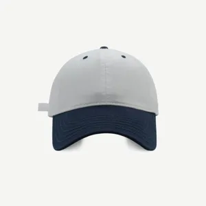 Primer plano de la gorra de béisbol bicolor, mostrando la corona gris y los detalles de la visera.