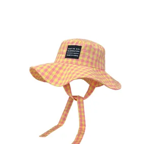Dettaglio cappello da pescatore a quadretti rosa giallo, tesa larga con laccetti.