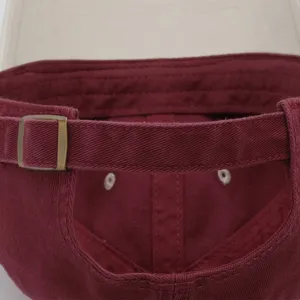 Detalle de hebilla metálica y correa de gorra de béisbol, diseño ajustable, vista en primer plano.