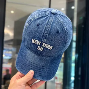 Nahaufnahme einer gewaschenen Jeans-Baseballkappe mit weißer New York-Stickerei.