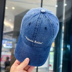 Nahaufnahme der blauen Jeans-Baseballkappe mit weißer Buchstaben-Bestickung und klassischem Design.