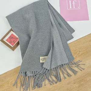 Nahaufnahme eines grauen Kaschmir-Gefühl Winterschals mit feiner Textur und Fransensaum.