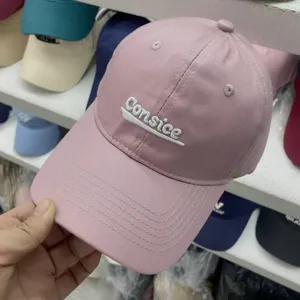 Primo piano dettagliato del berretto da baseball rosa con ricamo frontale e corona morbida.