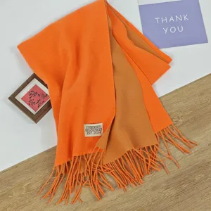 Gemütlicher doppelseitiger Winterschal in leuchtendem Orange und Braun mit stilvollen Fransen.