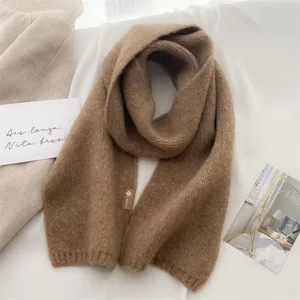 Gemütlicher kamelbrauner Strickschal im Detail mit weicher Textur für Damen im Winter.