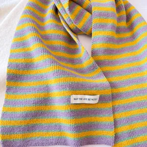 Gros plan sur les détails de texture d'écharpe rayée colorée en tricot doux automne hiver.