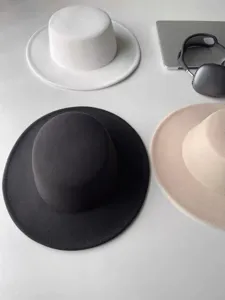 Klassischer flacher Hut mit breiter Krempe aus Filz in Schwarz, Weiß und Beige für Winter.