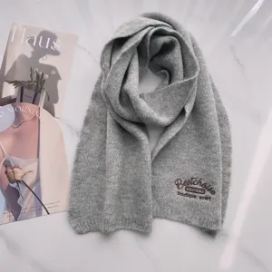 Grauer Strickschal aus Wolle mit feiner Stickerei, warmes Winteraccessoire Detailansicht.