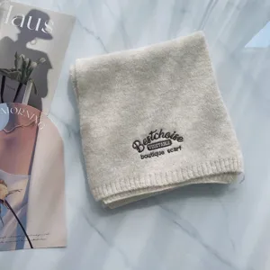 Gemütlicher Wollmischstrick-Schal mit zarter Bestickung, weiches Winteraccessoire.