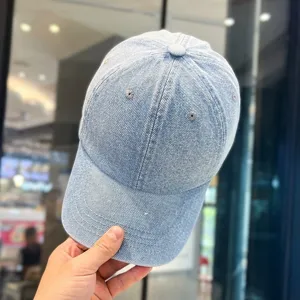 Detailansicht einer klassischen hellblauen Denim-Baseballkappe mit feiner Stoffstruktur.