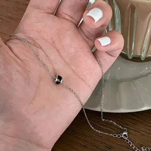 Collier chaîne argentée avec pendentif cylindre noir, élégant bijou de clavicule pour femmes.