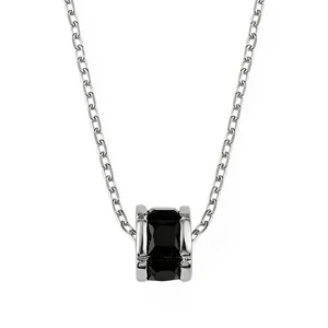Gros plan détaillé d'un collier chaîne en argent avec un pendentif cylindrique noir élégant.