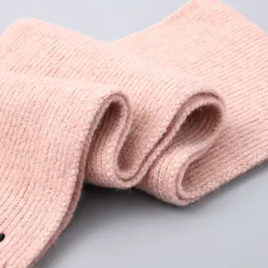 Close-up view of kids pink knit scarf texture, soft warm winter accessory detail presentation.