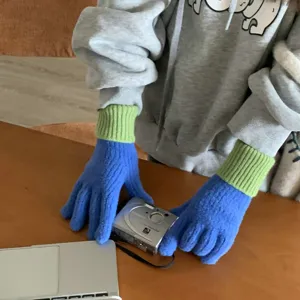 Gebreide kleurenblok handschoenen detailweergave, zachte textuur en blauwgroen design voor winter.