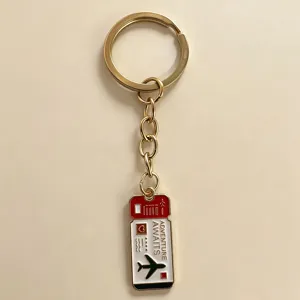 Detail shot of the travel themed airplane ticket metal keychain in stylish gold finish.