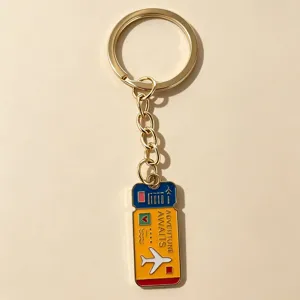 Closeup of the travel ticket metal keychain with airplane and adventure awaits text detail.