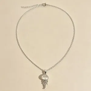 Clear glass jellyfish pendant necklace with silver chain, cute summer beach jewelry accessory.