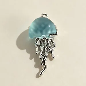 Close-up detail of a charming blue jellyfish pendant, silver metal tentacles, artistic jewelry.
