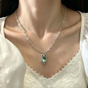 Vue détaillée du collier pendentif hibou en cristal vert menthe avec chaîne argentée.