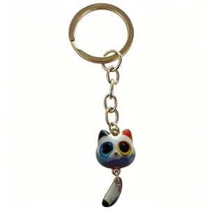 Cute calico cat keychain with big eyes and movable tail, stylish metal bag charm pendant.