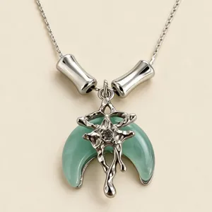 Gros plan détail du collier lune vert menthe avec pendentif étoile argent liquide.