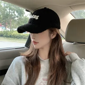 Detailed view of the winter warm black fuzzy baseball cap featuring white embroidered letters.