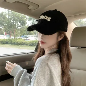 Black sherpa baseball hat detail, cozy winter fuzzy cap with embroidered letter design in car