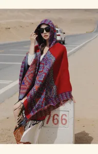Photo de détail de mode de voyage en plein air d'un poncho à capuche rouge à pompons.